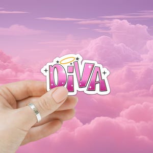 May include: A pink and white sticker with the word "DIVA" in a stylized font. The sticker has a halo and stars design, with a white border. The background is a pink cloudy sky.