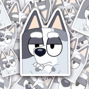 May include: A sticker of a cartoon dog with a white and gray fur pattern. The dog has a serious expression with its arms crossed and a frown on its face.