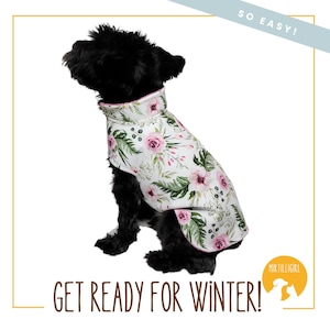 May include: A black dog wearing a white dog coat with a floral pattern. The coat has pink flowers and green leaves. The text "SO EASY!" is in the top right corner of the image. The text "GET READY FOR WINTER!" is at the bottom of the image. The text "MIR TILLIGIRL" is in a circle in the bottom right corner of the image.