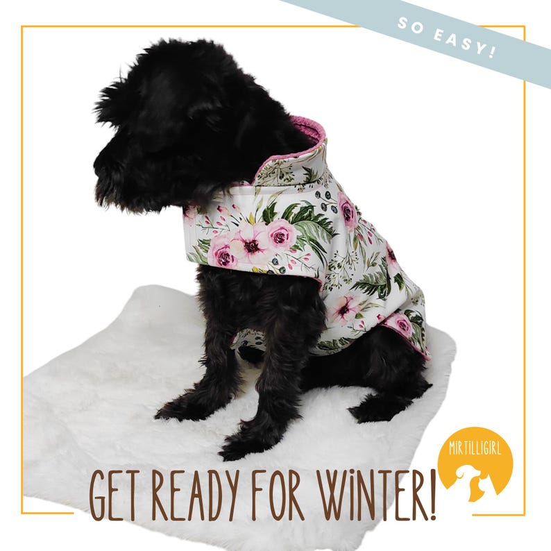 May include: A black dog wearing a white and pink floral dog coat with a pink lining. The dog is sitting on a white fluffy surface. The text "SO EASY!" is in the upper right corner of the image. The text "GET READY FOR WINTER!" is in the lower left corner of the image. The text "MIR TILLIGIRL" is in the lower right corner of the image.