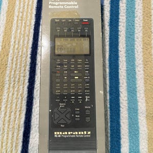May include: A Marantz RC-40 programmable remote control in its original packaging. The black remote features buttons for CD, tuner, and volume control. The packaging displays the Marantz logo and the remote's model number, with text in English.