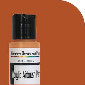 Puede incluir: Una botella de pintura acrílica para aerógrafo de color óxido. La botella tiene una tapa negra y una etiqueta con el texto "Modelers Decals and Paint" y "Rust - 16038-2". La pintura es un tono marrón anaranjado.