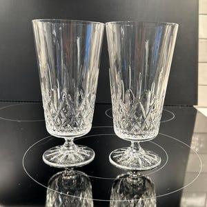 May include: A set of three ceramic mugs with a speckled, cream-colored glaze. Each mug features a different hand-painted floral design in shades of blue, green, and yellow. The mugs have a simple, rounded shape and a comfortable handle.