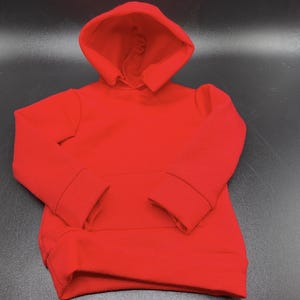 May include: A vibrant red hoodie with a hood and long sleeves. The sweatshirt has a kangaroo pocket and ribbed cuffs and hem. The garment is made of a soft, comfortable material.