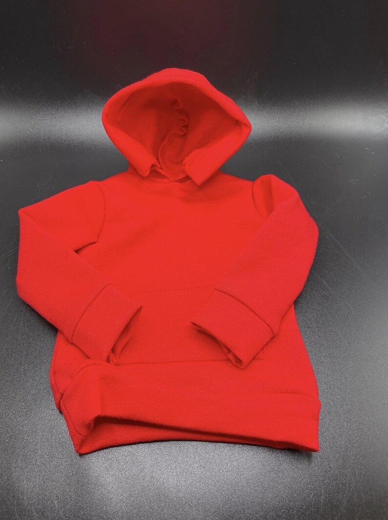 May include: A vibrant red hoodie with a hood and long sleeves. The sweatshirt has a kangaroo pocket and ribbed cuffs and hem. The garment is made of a soft, comfortable material.