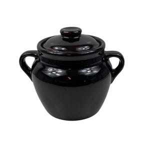 Puede incluir: Una olla de cerámica de color marrón oscuro brillante con tapa a juego y dos asas laterales. El recipiente presenta un cuerpo redondeado y un acabado liso y reflectante, mostrando un color profundo y uniforme en toda la superficie exterior.