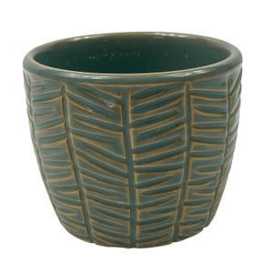 May include: A teal ceramic planter with a rounded shape and a textured exterior featuring vertical columns of recessed, horizontal, tan-coloured grooves that wrap around the entire circumference of the vessel.