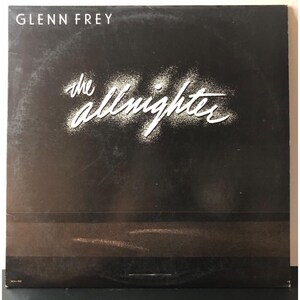 Puede incluir: Portada de álbum de vinilo negro con texto blanco que dice "Glenn Frey" y "the almighty" en una fuente estilizada.