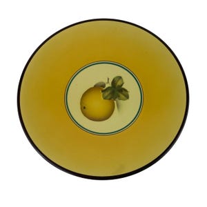 May include: A round ceramic plate featuring a vibrant yellow border and a dark brown rim. The center of the plate is a lighter cream color, enclosed by a thin green circular line, and displays a single yellow citrus fruit with green leaves.