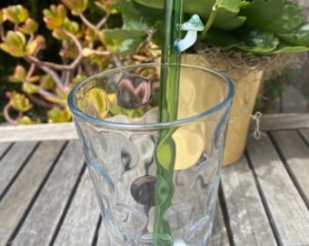 Handmade Green Glass Straw with a Mini glass mushroom on top of it .