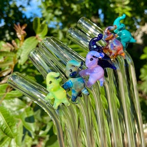 Pu&ograve; includere: Un set di sei cannucce da bere in vetro con topper in vetro a forma di elefante colorati. Gli elefanti sono in tonalit&agrave; di verde, blu, viola, arancione e turchese.