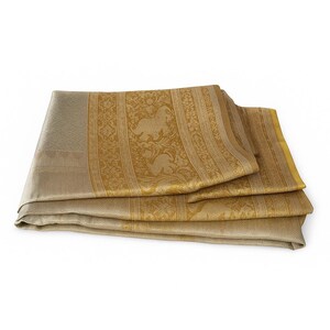 May include: Folded gold and beige textile with intricate patterns. The textile features a repeating design of stylized animals and floral motifs. The edges are bordered with a solid gold color. The fabric is folded in a layered arrangement.