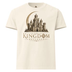 May include: Cream-colored t-shirt featuring a detailed illustration of a castle under a crescent moon. The text "THE KINGDOM RETURNED" is printed below the castle in a serif font. A classic crew neck tee.