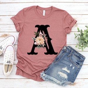 Camiseta com monograma floral e letras enfeitadas, camiseta personalizada com letra A de flor, camiseta lilás com iniciais, camiseta boho de flor de A a Z