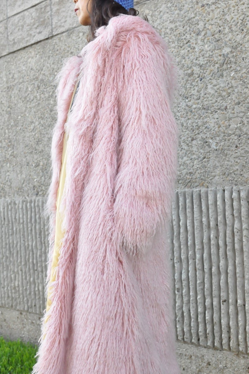 Puede incluir: Una larga y peluda chaqueta de piel sint&eacute;tica de color rosa.