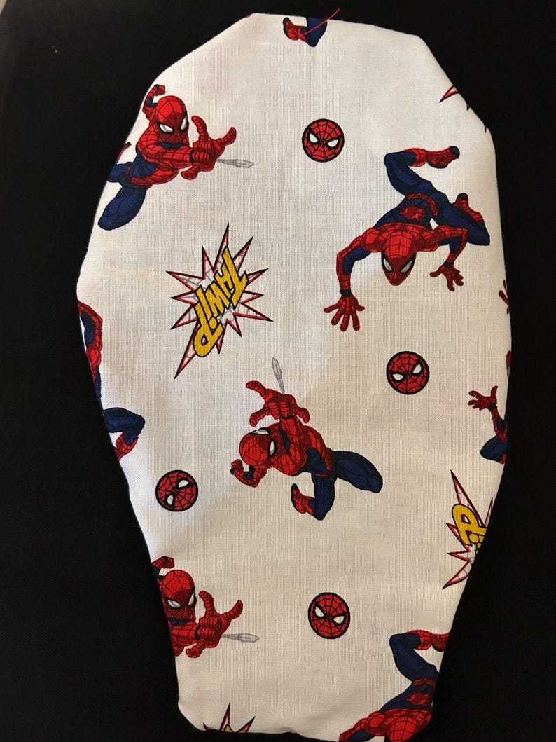 May include: White fabric with a repeating pattern of Spiderman in a red and blue suit, a red spider symbol, and a yellow comic book style "POW!" sound effect.