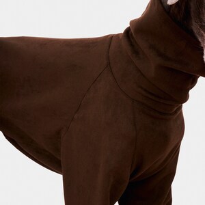May include: A brown suede dog sweater with a high turtleneck collar.
