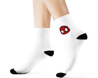 May include: White ankle socks with black heels and toes. The socks feature a red and black Spider-Man logo on the side. These socks are a fun accessory for fans of the superhero.