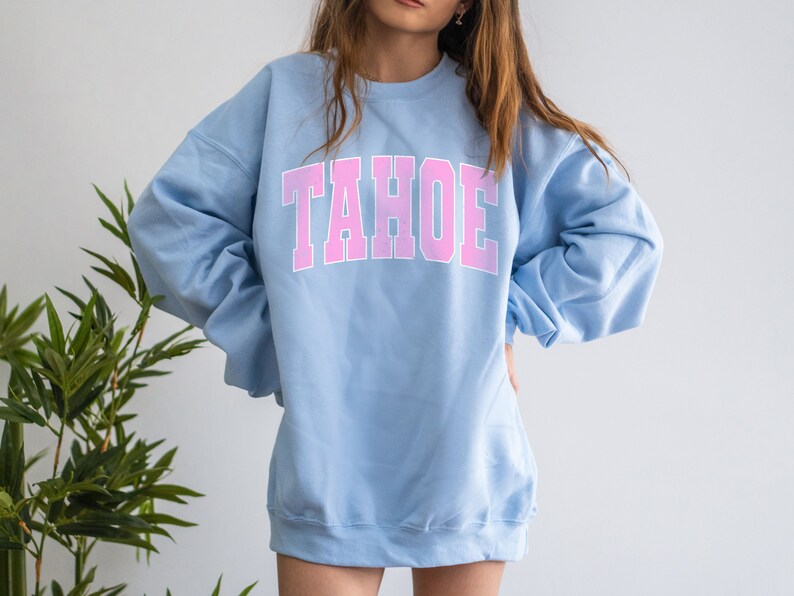 May include: A light blue sweatshirt with the word "TAHOE" printed in pink on the front.
