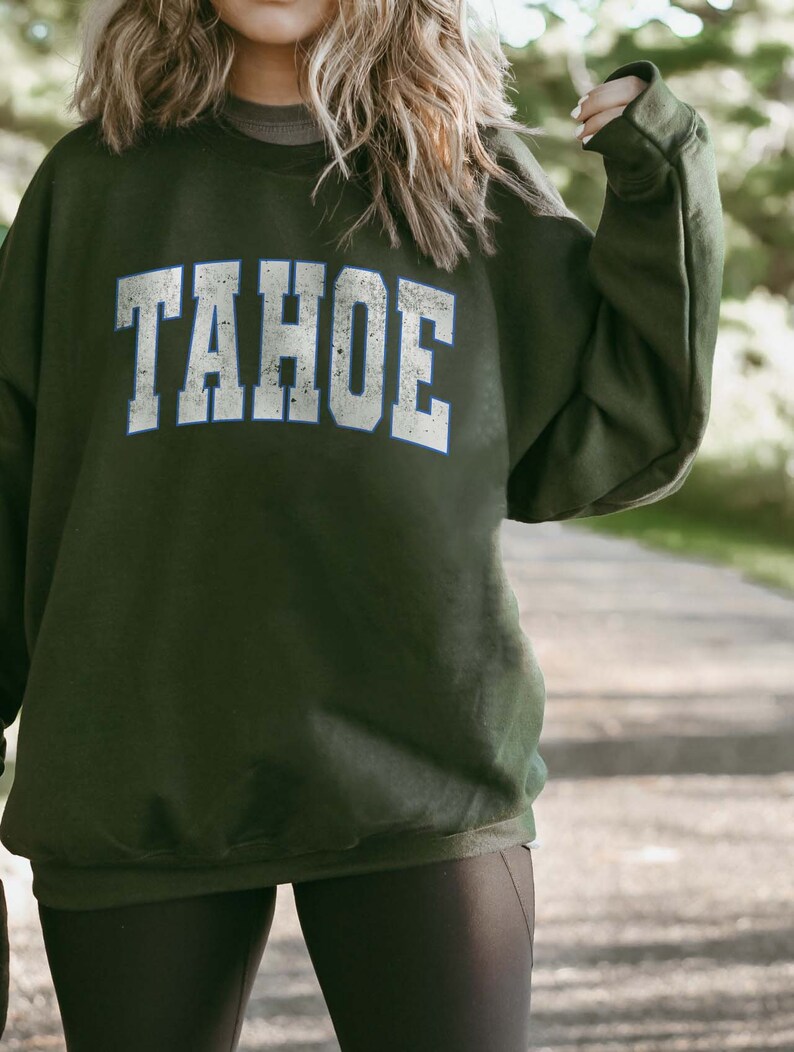 May include: A dark green sweatshirt with the word "TAHOE" printed in white with a blue outline.