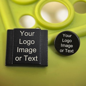 Puede incluir: Etiquetas de logotipo personalizadas, cuadradas y redondas, negras con texto blanco "Your Logo Image or Text". Las etiquetas están sobre una superficie verde lima con recortes circulares y ovalados.