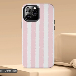 May include: A pink and white striped phone case with a distressed look. The case has a cutout for the camera lens.