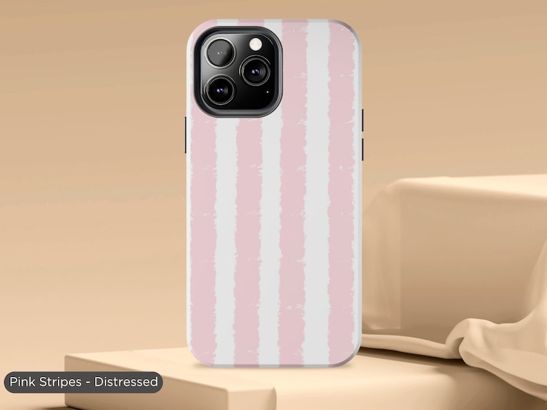 May include: A pink and white striped phone case with a distressed look. The case has a cutout for the camera lens.