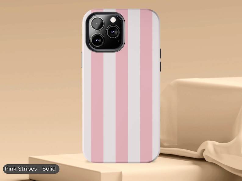 May include: A pink and white striped phone case for an iPhone. The case has a solid colour design with vertical stripes.