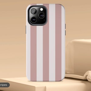 May include: A pink and white striped phone case for an iPhone. The case has a camera cutout and a beige stripe pattern.