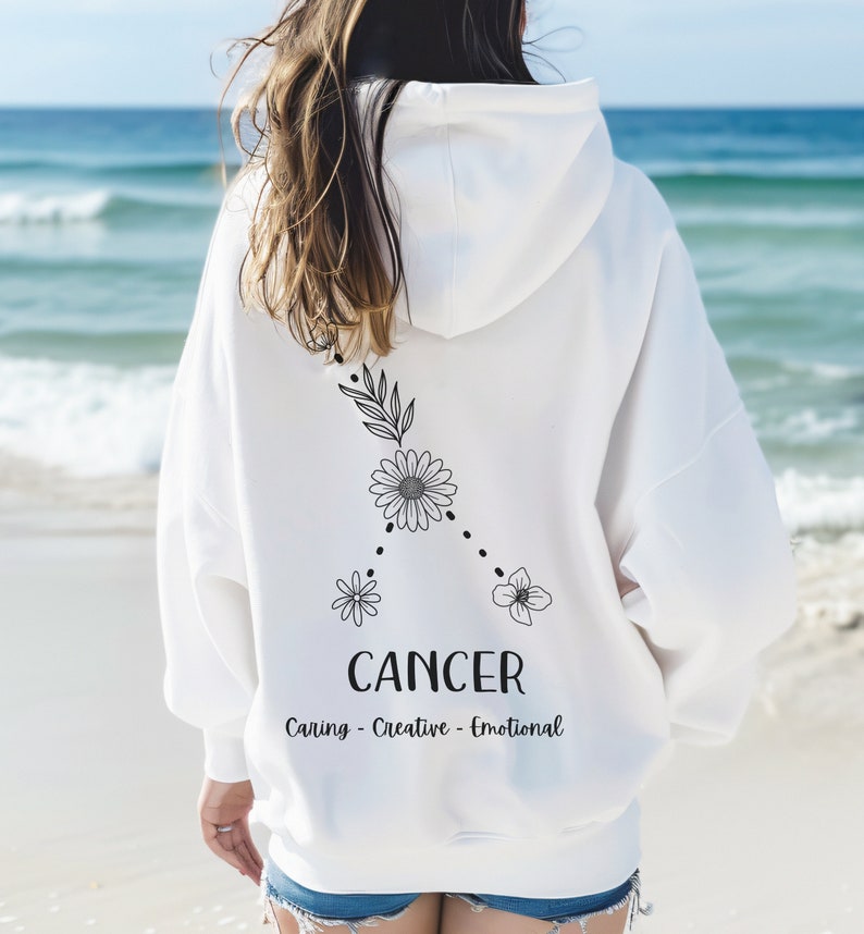 Puede incluir: Sudadera blanca con un signo zodiacal de C&aacute;ncer floral negro y el texto "Caring - Creative - Emotional".