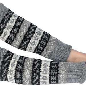 May include: Pair of gray, black, and white striped knitted leg warmers. The leg warmers have a geometric pattern.
