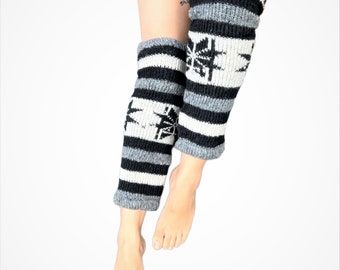 May include: A pair of black and white striped leg warmers with a snowflake design. The leg warmers are made of a soft, knitted fabric.