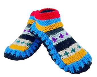 Puede incluir: Un par de pantuflas de lana tejidas de colores con base negra y rayas azules, amarillas, rojas y moradas.
