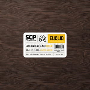 Peut inclure: Un autocollant rectangulaire blanc avec du texte et des graphiques noirs et jaunes. Il présente le logo de la Fondation SCP, le mot EUCLID dans un encadré jaune, un code-barres et le texte CONTAINMENT-CLASS: EUCLID et OBJECT CLASS: LIMITED ACCESS.