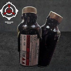 Könnte beinhalten: Zwei Glasflaschen gefüllt mit einer dicken, dunklen, viskosen schwarzen Substanz, jeweils mit einem Metallverschluss. Die vordere Flasche hat ein weißes Etikett mit rotem und schwarzem Text, der DANGER, KETER, SCP-106 und SECURE, CONTAIN, PROTECT lautet.