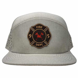 Pode incluir: Um boné de beisebol cinza e preto com um remendo de couro que apresenta um logotipo vermelho do departamento de bombeiros com o texto "FIRE DEPT. 95".