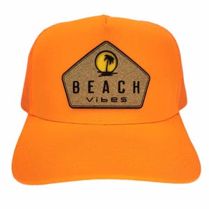 May include: Orange trucker hat with a cork patch that says "BEACH vibes" and a silhouette of a palm tree and sun.