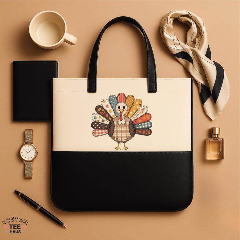 K&ouml;nnte beinhalten: Eine zweifarbige Tragetasche mit schwarzem Boden und cremefarbenem Oberteil. Der cremefarbene Bereich zeigt ein farbenfrohes Truthahn-Design. Die Tasche hat schwarze Griffe und ist von einer Uhr, einem Stift, einem Schal, Parf&uuml;m, einem Notizbuch und einer Tasse umgeben.