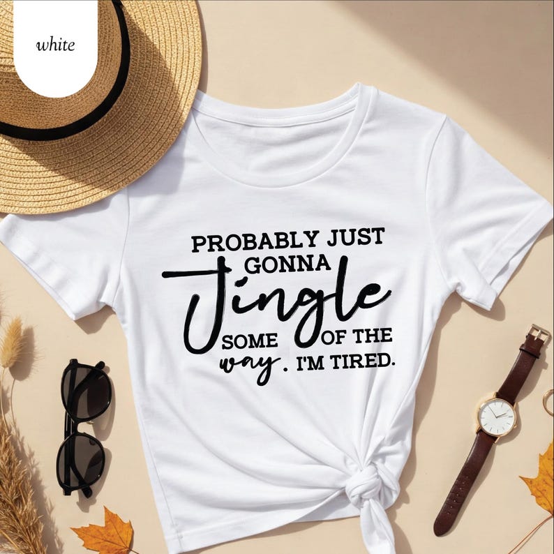 May include: White t-shirt with the text "PROBABLY JUST GONNA Jingle SOME OF THE WAY. I'M TIRED." The shirt is knotted at the waist. A straw hat, sunglasses, and a wristwatch are also visible.
