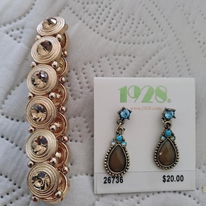 Bracciale color oro, orecchini a goccia del 1928, mai indossati.
