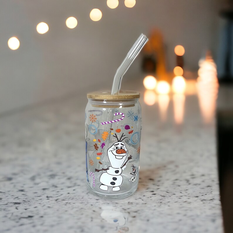Puede incluir: Un vaso de beber de vidrio transparente con una tapa de bamb&uacute; y una pajita. El vaso tiene un dise&ntilde;o colorido con Olaf de la pel&iacute;cula Frozen. El dise&ntilde;o incluye copos de nieve, bastones de caramelo y hojas.