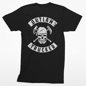 May include: Black t-shirt with a white graphic of a skull wearing a bandana and holding two crossed wrenches. The graphic is surrounded by a white banner that reads "OUTLAW TRUCKER".