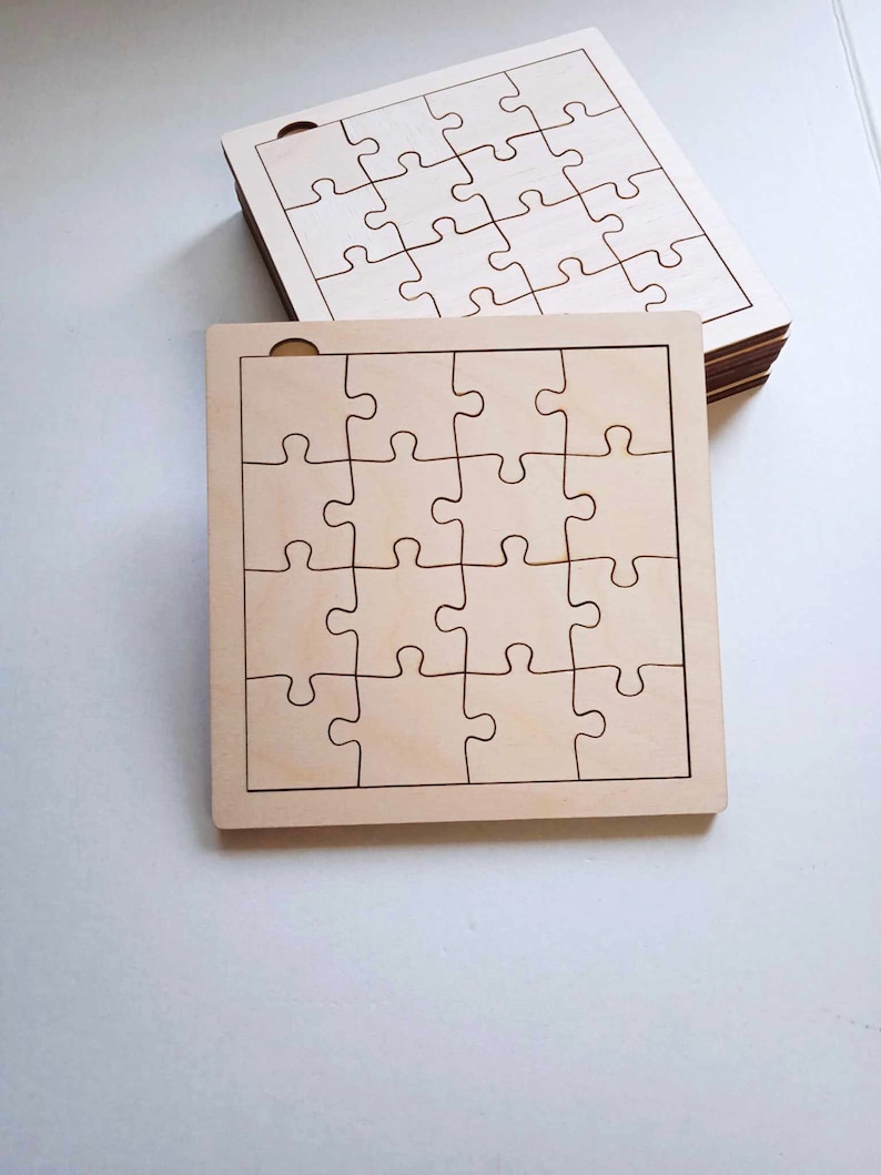 May include: Two unfinished wooden jigsaw puzzles with a 5x5 grid of puzzle pieces. The puzzles are made of light brown wood and have a smooth surface.