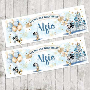 May include: Two banners with a light blue background, featuring Mickey Mouse illustrations, balloons, and a castle. The text "Happy 1st Birthday Alfie" is displayed on each banner. Gold confetti and fireworks complete the design.