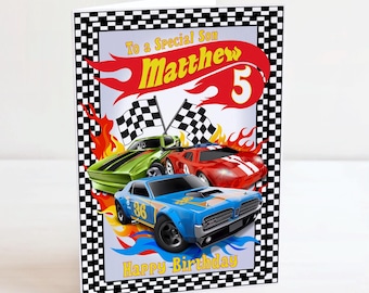 Puede incluir: Tarjeta de cumpleaños con ilustraciones de tres coches de carreras en verde, rojo y azul, con llamas y banderas a cuadros. La tarjeta dice: "To a Special Son Matthew 5 Happy Birthday".