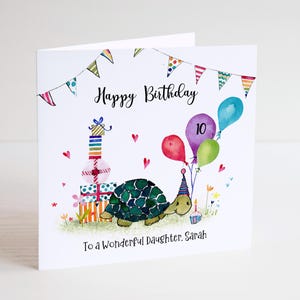 May include: A birthday card with a watercolour illustration. The card features a turtle with a party hat, balloons, and presents. The text reads "Happy Birthday" and "To a Wonderful Daughter, Sarah."