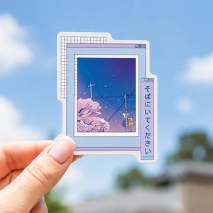 May include: A die-cut sticker featuring a light blue computer window frame with a grid pattern in the corner. The central image displays a night sky with utility poles, power lines, and pink cherry blossom trees. Japanese text is on the side.