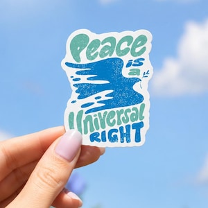 以下が含まれることがあります： 中央に青い鳥のシルエットが描かれ、レトロなフォントで「Peace is a UNIVERSAL RIGHT」というテキストが印刷されたダイカットステッカー。ステッカーには白い縁取りがあり、ライトティール、ミディアムブルー、ダークブルーのカラーパレットが使用されています。