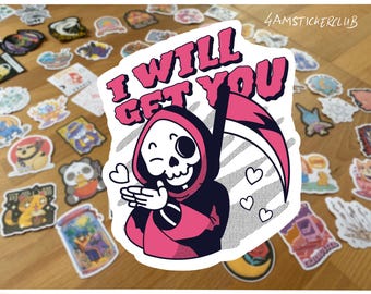 May include: A sticker featuring a cartoon Grim Reaper with a scythe, winking and blowing kisses. The text "I WILL GET YOU" is in pink bubble letters. The sticker is surrounded by other stickers on a wooden surface.