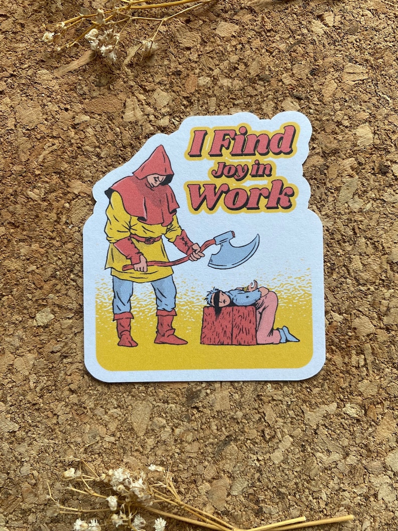 May include: A sticker with a cartoon illustration of a person in a red hooded robe holding an axe over a person kneeling on a block. The text on the sticker reads "I Find Joy in Work".